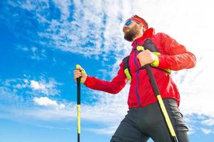 Mann mit Stöcken zwischen Nordic Walking mit Himmelshintergrund foto