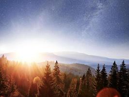 Berglandschaft im Herbst. hohes gras und lebendiger nachthimmel mit sternen und nebel und galaxien. Deep-Sky-Astrofoto foto