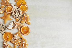 weihnachtslebkuchenplätzchen und getrocknete orange und gewürze auf weißem tisch