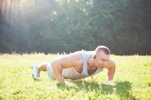 Ein junger Sportler, der sich auf das Sport- und Fitnesstraining im Freien vorbereitet. Sport, Bewegung, Fitness, Training. gesunder Lebensstil foto