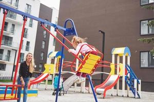 Mutter mit Kind auf dem Spielplatz foto