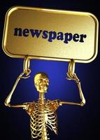 Zeitungswort und goldenes Skelett foto