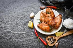 Gebackene Hühnerflügel mit Saucenkräutern und Gewürzen, die thailändisches asiatisches Essen kochen Rosmarinhuhn gegrillt. foto
