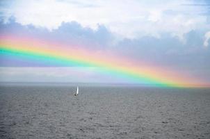 Aquarellzeichnung einer kleinen weißen Segelyacht und eines Regenbogens im Finnischen Meerbusen in der Ostsee