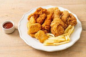 Brathähnchen mit Pommes Frites und Nuggets auf Teller foto