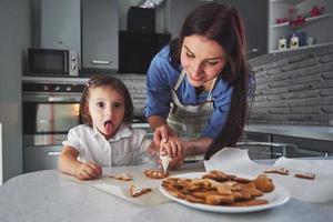 mutter backt mit ihrer tochter in der küche. foto