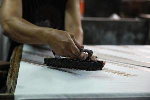 Hand von Handwerkern, die traditionelle indonesische Stoffe namens Kain-Batik herstellen foto