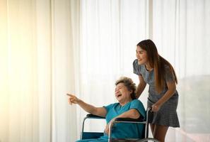 Tochter einer älteren Patientin, die die Mutter versorgt und ermutigt foto