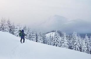 schneeschuhwanderer, der im pulverschnee mit schönem sonnenaufgangslicht läuft. winteraktivitäten im freien und gesunder lebensstil foto