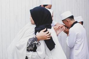 muslimischer freund und familie grüßen sich umarmen und feiern eid mubarak foto