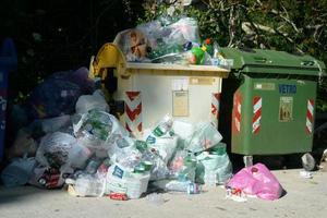 Kommunale Mülleimer mit Plastik- und Aluminiumabfällen, die mit Containern überquellen. Kommunalabfälle quellen mit Containern über. foto