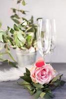 komposition mit glas für champagner. blumen und herzen auf grauem betonhintergrund. foto