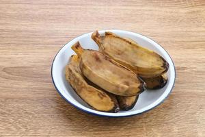 pisang kukus oder gedämpfte banane, indonesisches traditionelles essen, ein gesunder snack. auf Holztisch serviert. Nahansicht. foto