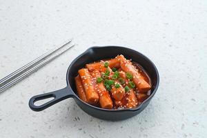 tteokbokki oder topokki, gebratener reiskuchenstock, beliebtes koreanisches straßenessen mit würziger gochujang-sauce und sesamsamen. foto