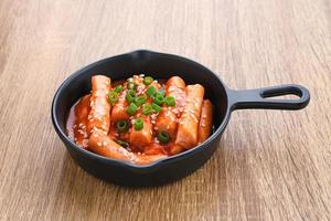 tteokbokki oder topokki, gebratener reiskuchenstock, beliebtes koreanisches straßenessen mit würziger gochujang-sauce und sesamsamen. foto