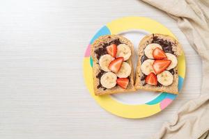 Vollkornbrot mit frischer Banane, Erdbeere und Schokolade foto