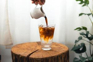 schwarzer Eiskaffee in einer Tasse im Zimmer foto