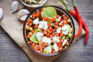 Fischsauce auf Glasschale und frischer Chili Knoblauch Zitrone Limette und kleiner getrockneter Fisch auf Sack, Fischsauce aus Fermentationsfisch oder kleinen Wassertieren, fermentierte Lebensmittel foto