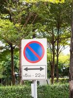 Zeichen, die das Parken auf einem grünen Baumhintergrund verbieten. foto