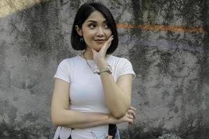 denkende Geste des asiatischen schönen Mädchens mit weißem Hemd im weißen Hintergrund foto