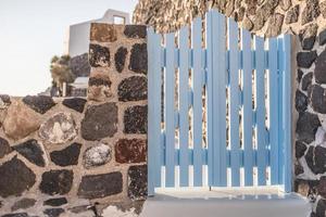 fantastischer reisehintergrund, stadtlandschaft von santorini. holztür oder tor mit treppe und weißer architektur unter sonnenlicht. idyllisches sommerferienferienkonzept. wunderbare Sommer-Luxus-Vibes foto