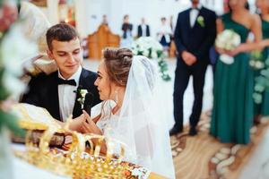 Bräutigam legt der Braut während der Hochzeit einen Ring an den Finger foto