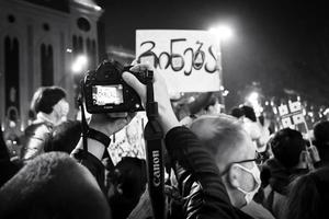 Tiflis, Georgien, 2022 - Fotograf fotografiert Plakat aus Protest foto