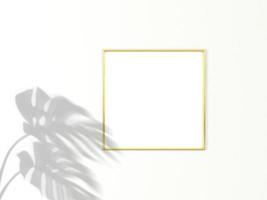 1x1 quadratischer Goldrahmen für Foto- oder Bildmodell auf weißem Hintergrund mit Schatten von Monstera-Blättern. 3D-Rendering. foto