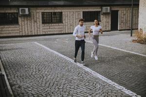 junges Fitnesspaar läuft im Stadtgebiet foto