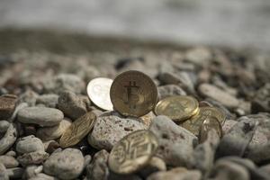 Bitcoin-Kryptowährung. E-Währung. Meer. Sommerstrand. Meeressteine foto