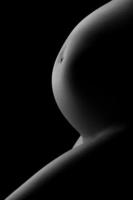 Bauch einer schwangeren Frau auf dunklem Hintergrund foto