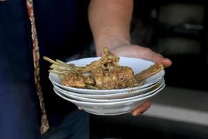 würziges Tengkleng Gajah. Ziegenfleisch mit Rippen und Knochen, gekocht mit Suppe. indonesisches traditionelles essen aus grilllammknochen isoliert auf schwarzem holzhintergrund foto