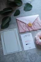 Hochzeitseinladung in einem grauen Umschlag auf einem Tisch foto