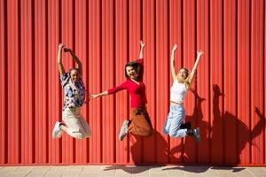 begeisterte Frauen, die in der Nähe der Wand springen foto