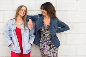 zwei junge Frauen, die im städtischen Hintergrund lächeln foto