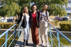 lächelnde gemischtrassige Frauen auf der Fußgängerbrücke foto