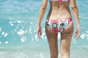 sexy Rücken einer schönen Frau im Bikini auf Meereshintergrund. foto