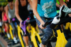 leute trainieren in einem fitnessstudio und machen cyclo indoor. foto