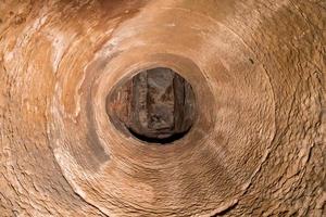 Blick nach oben von einem Brunnenschacht aus Sandstein foto