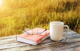 Tasse Kaffee und Notizbuch auf Holztisch foto