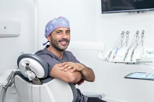 Foto mit Kopierbereich eines Zahnarztes, der auf einem Stuhl in einem Klinikraum sitzt