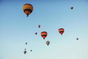 Gruppe von bunten Heißluftballons vor blauem Himmel foto