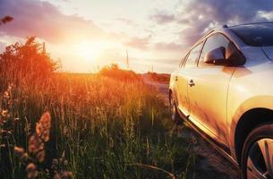 Straßenauto auf einem Feld bei Sonnenuntergang. Ukraine Europa foto