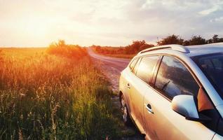 Straßenauto auf einem Feld bei Sonnenuntergang. Ukraine Europa foto