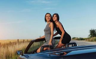 Schöne zwei Frauen sitzen in einem Cabrio foto