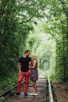 Liebespaar in einem Tunnel aus grünen Bäumen auf der Eisenbahn foto