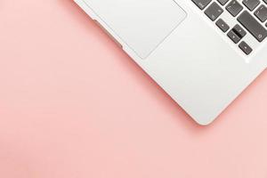Tastatur-Laptop-Computer isoliert auf rosa Pastellschreibtischhintergrund. moderne Informationstechnologie und Software Fortschritte foto