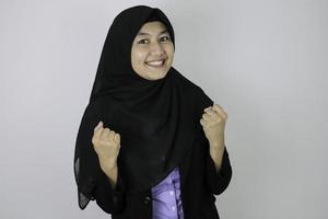Aufgeregt und Geste gewinnen Junge asiatische Islamfrau mit Kopftuch. foto