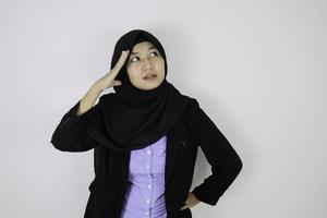 ernsthafte tagträumende geste junge asiatische islamfrau mit kopftuch. foto