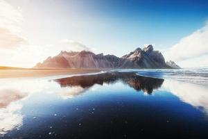 Erstaunliche Berge, die sich bei Sonnenuntergang im Wasser spiegeln. stoksnes, ic foto